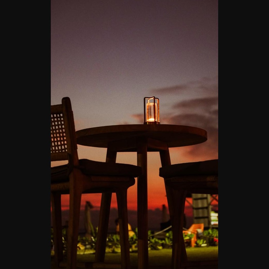 A candlelit table set on a terrace at dusk