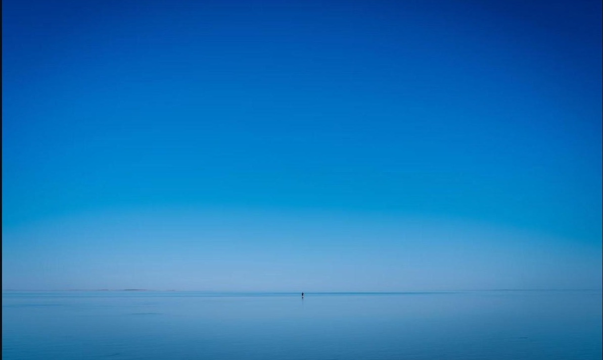 Calm, wide ocean horizon at dawn